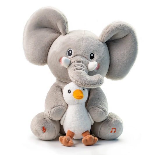 A cute, plush elephant stuffed animal with oversized ears and rosy cheeks is hugging a smaller plush chick. The elephant has embroidered eyes and tusks, with a microphone icon on one foot and a music note on the other, indicating it has interactive and recordable features.