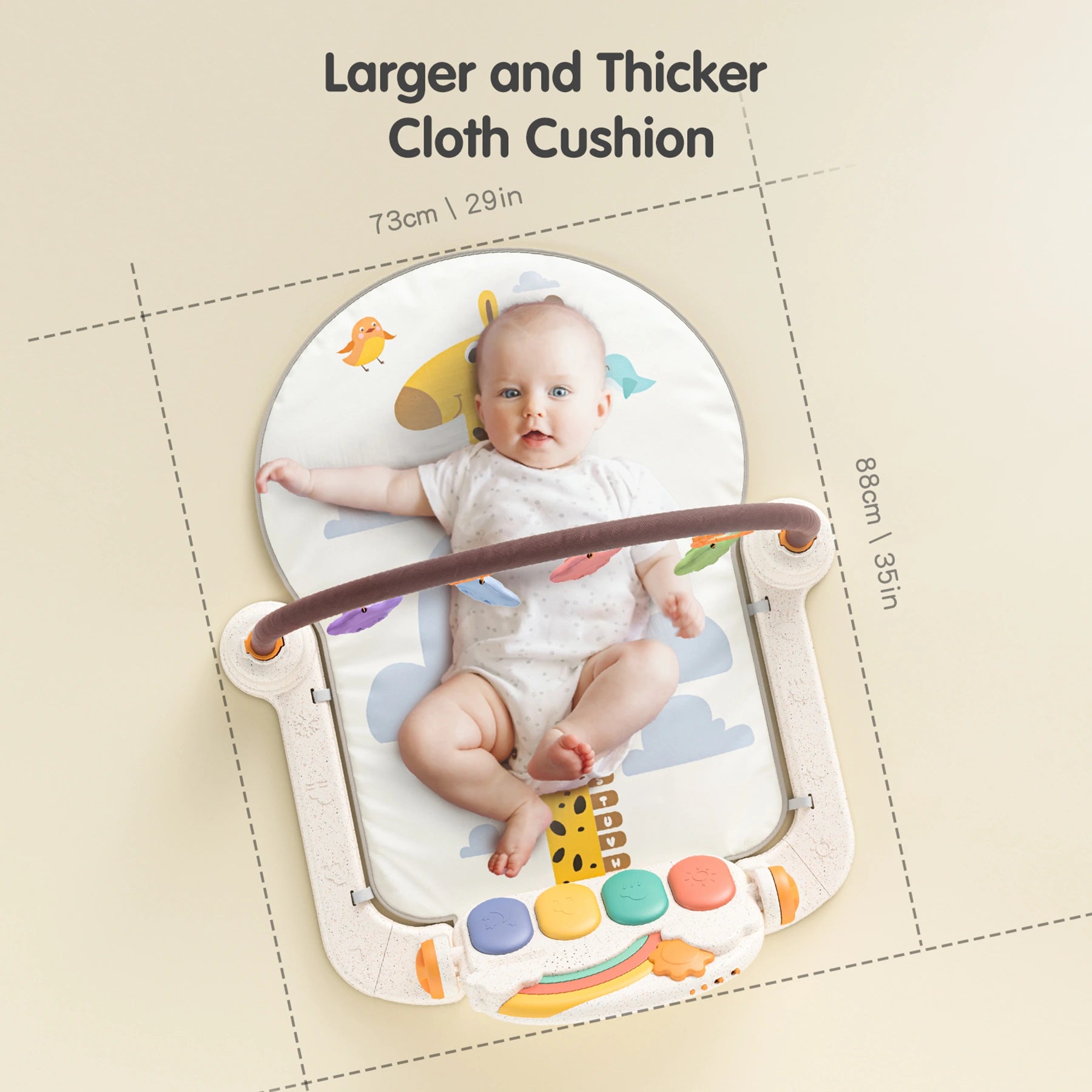 Smiling baby lying on a larger and thicker cloth play mat and gym with colorful hanging toys and musical buttons, measuring 88cm by 73cm, designed for early development and comfort.