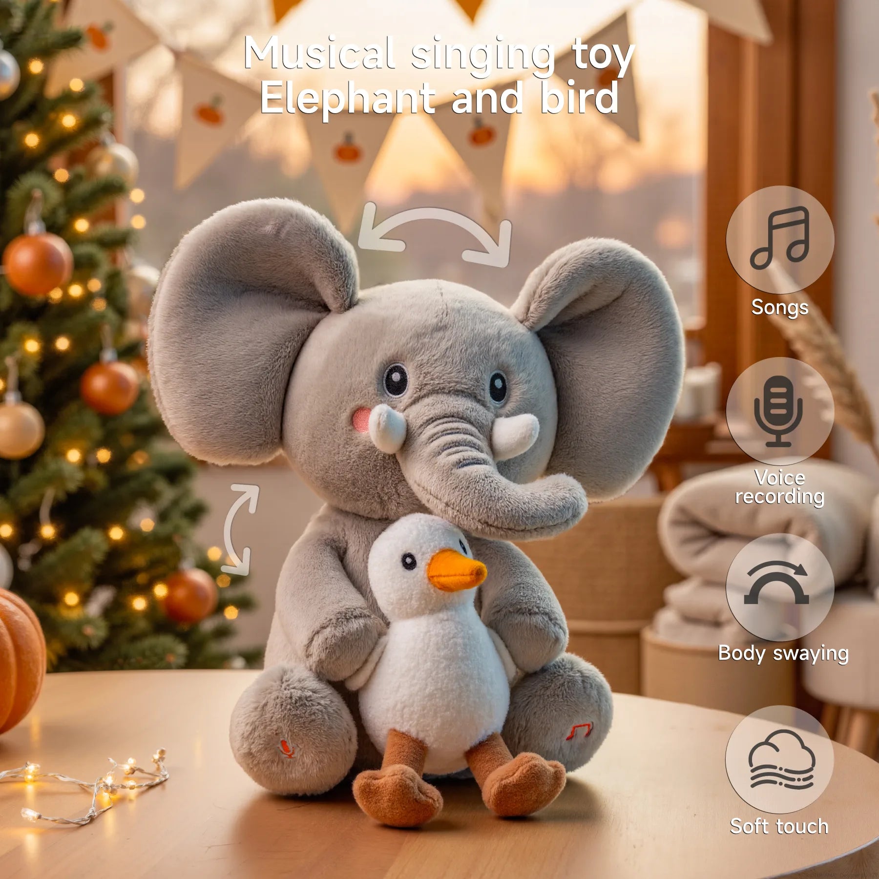 A interactive plush musical elephant toy with large ears and rosy cheeks is hugging a small bird plush. Arrows around the elephant indicate head and body movement features. Overlay icons on the right list its features: songs, voice recording, body swaying, and soft touch. 