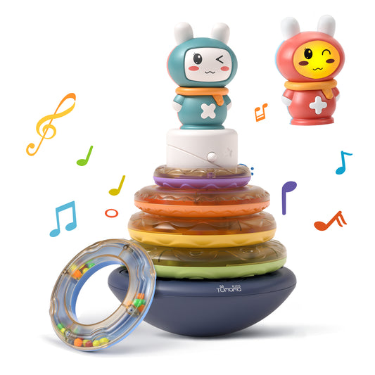 Colorful baby stacking rings toy with a musical feature. The toy includes a wobbling base, five translucent rainbow rings, and a cute bunny topper that can play music. One ring is shown separately with beads inside for sensory play. 