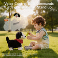A young child playing with a voice-controlled realistic toy dog wearing a red bandana, holding a green bone while the toy responds to the voice command “Stand” in a sunny park.